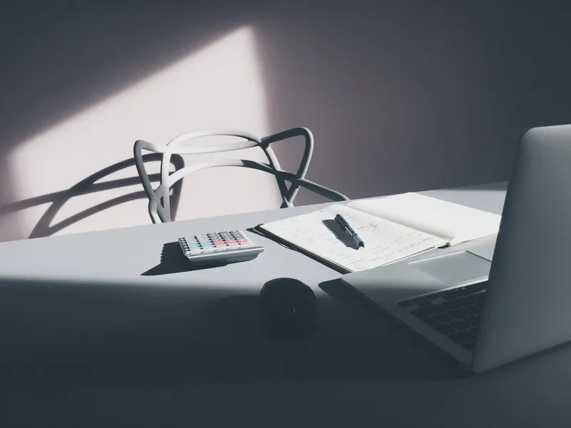 Business owner reviewing a stack of telecom bills with a laptop and highlighter