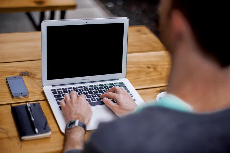 Business owner replying to a customer inquiry on a laptop at a front desk