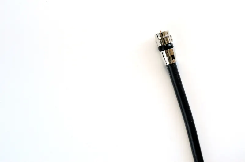 Split view of fiber-optic strands and coaxial cable connectors on a desk