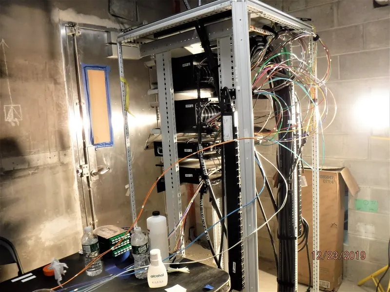 Office manager reviewing an installation checklist beside an open network cabinet
