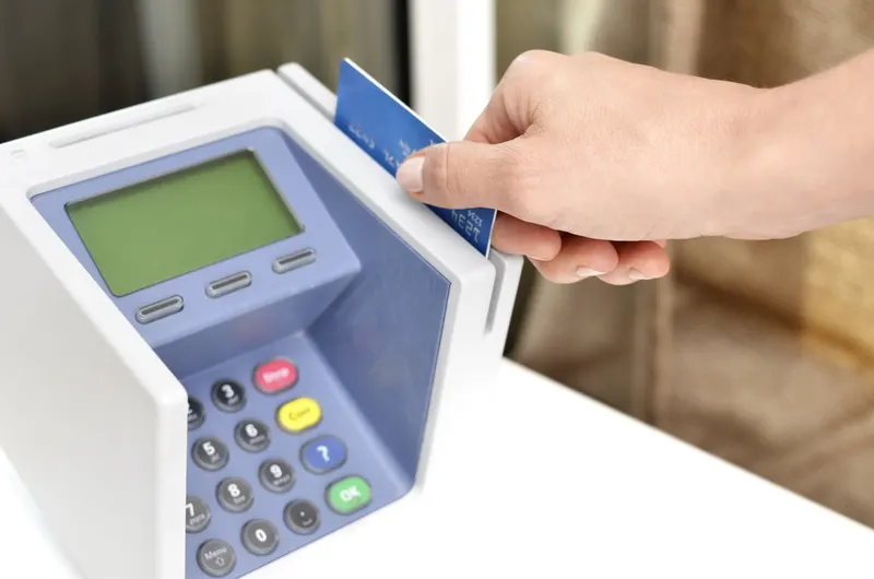 Cashier processing a card payment at a retail point-of-sale counter
