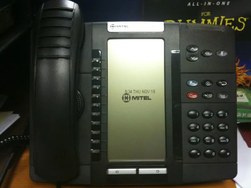 Desk phone and network switch side by side in a small office
