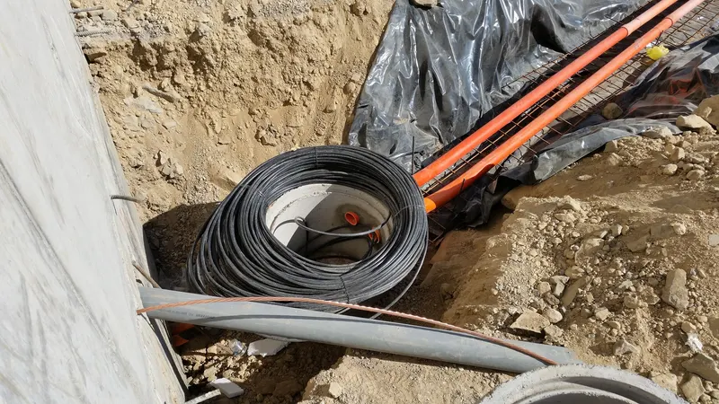 Technician connecting fiber-optic cables in a Dallas office network cabinet