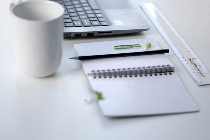 Organized folder of bills, floor plan and notes laid out on an office desk