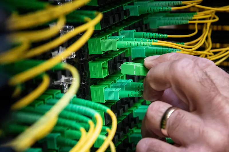 Fiber-optic network cables patched into a data cabinet