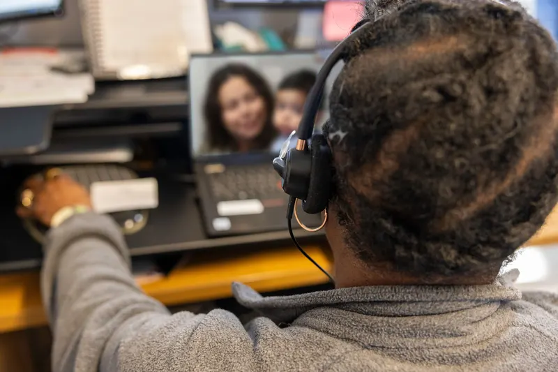 Employee on a headset call at a laptop in a bright office